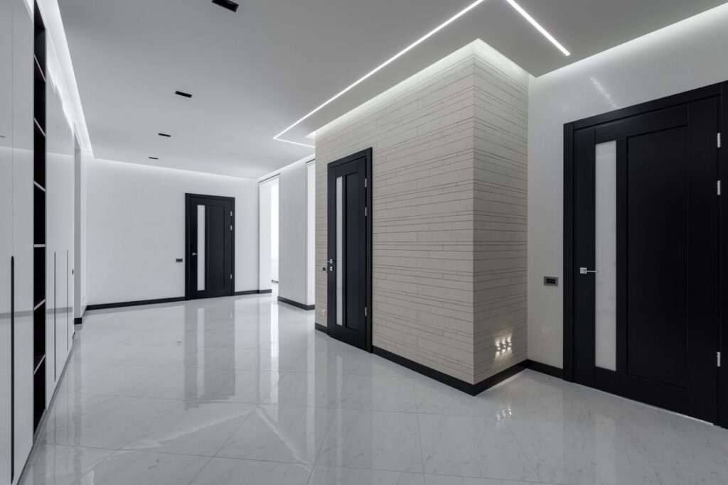 pexels photo 6238608 6238608 Modern spacious corridor with white walls and floor and black doors and ceiling decorated with LED lights